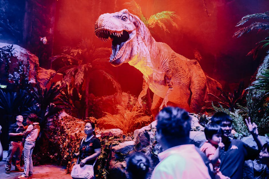 Imposing Tyrannosaurus Rex model in a museum exhibit with visitors exploring prehistoric era themes.