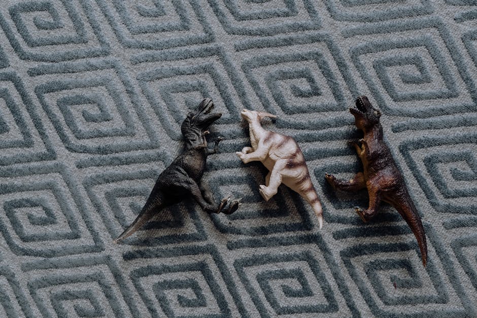 Three dinosaur toys arranged on a textured geometric carpet, displaying a playful still life scene.
